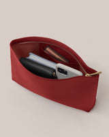 Red zippered pouch with phone, wallet, notebook, and a lipstick inside.