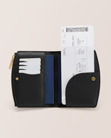 Open wallet with cards and a boarding pass inside, featuring snap closure and zipper detail.