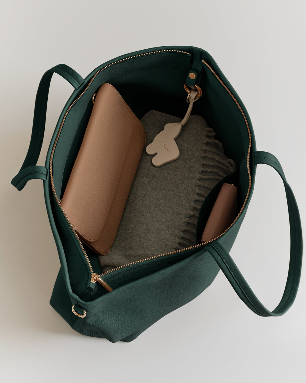 Open tote bag with items like a wallet and folded fabric inside