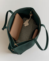 Open tote bag with items like a wallet and folded fabric inside