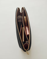 Open makeup bag with brushes and cosmetics inside.