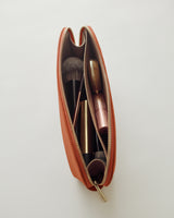 Makeup brushes and cosmetics in a zippered pouch.