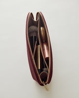 Makeup bag with brushes and lipstick inside.