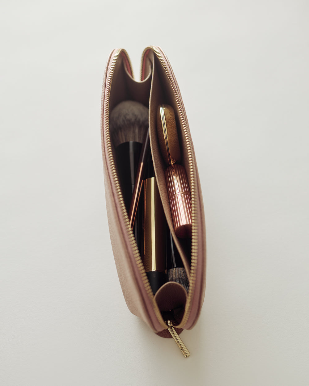 Makeup bag with brushes and lipstick inside.