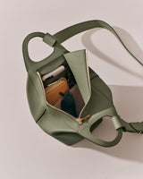 Open travel bag with wallet, sunglasses, and phone inside.