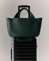 Handbag sitting on a suitcase handle.
