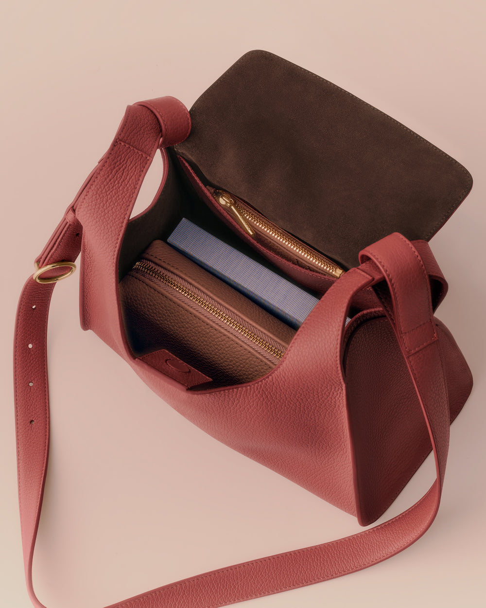 Open handbag with two zippered compartments and a shoulder strap.