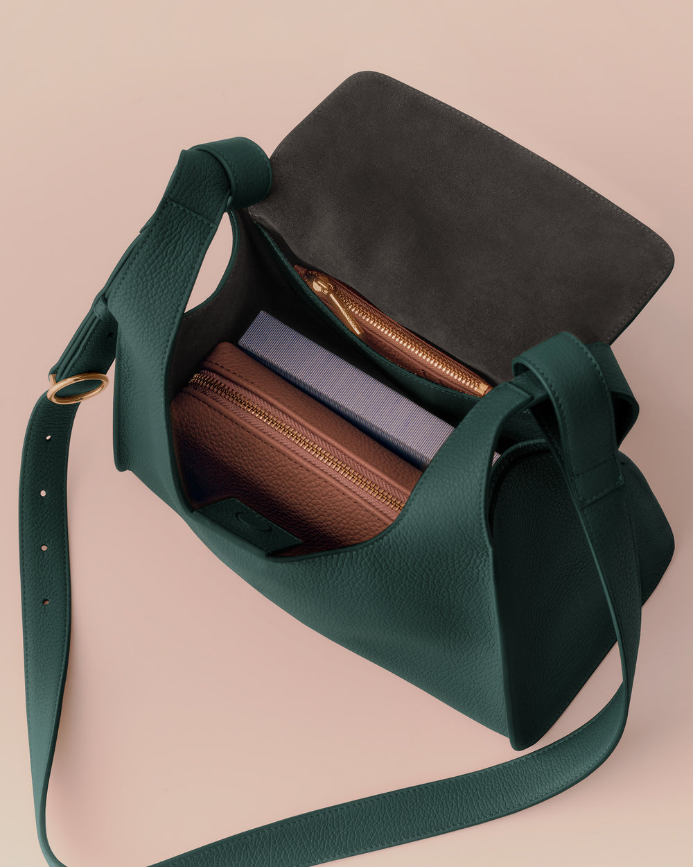 Open shoulder bag with items inside, including a wallet and a notebook.