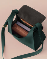 Open shoulder bag with items inside, including a wallet and a notebook.