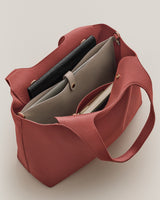 Open tote bag with folders and wallet inside.