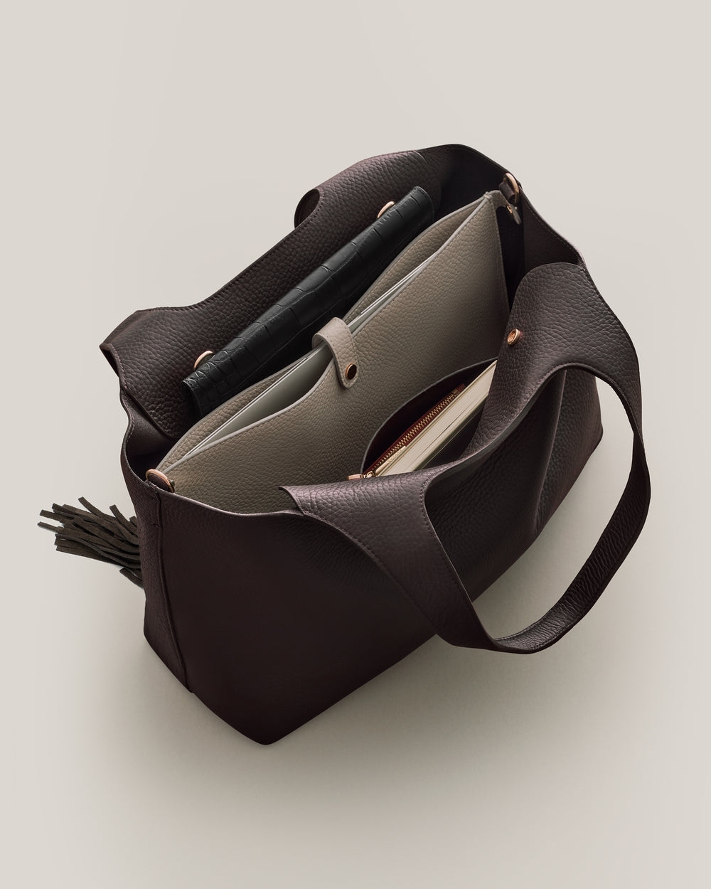 Open tote bag containing laptop sleeve and a book.