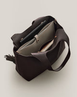 Open tote bag containing laptop sleeve and a book.