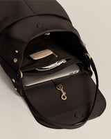 Open travel bag with a laptop and small accessories inside.
