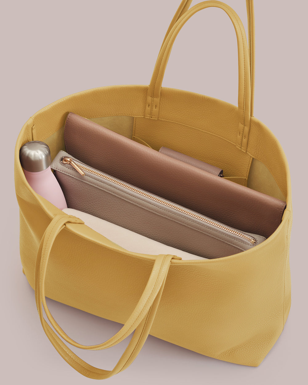 Open tote bag with a water bottle and three pouches inside.