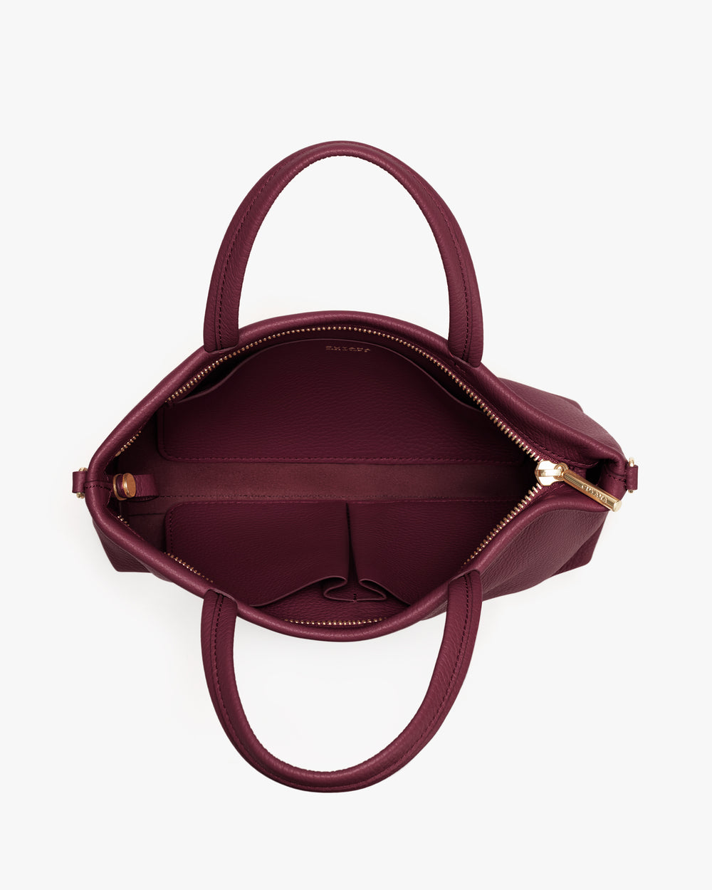 Top view of an open handbag with two handles and a zippered compartment.