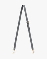 Adjustable bag strap with metal clasps and a buckle.