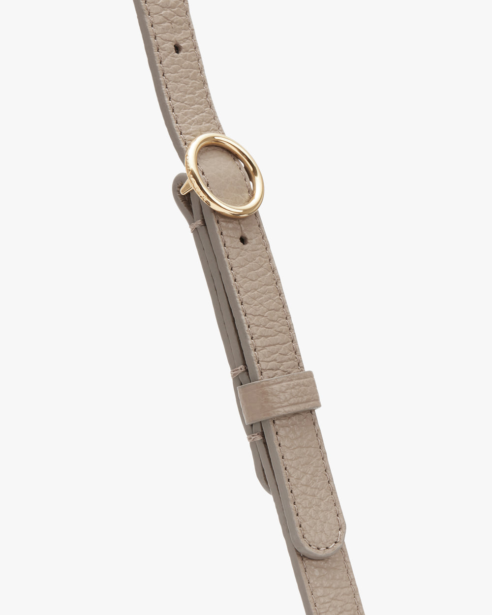 Close-up of a textured strap with a circular metal buckle.