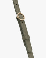 Close-up of a strap with a metal ring buckle and adjustable loop.