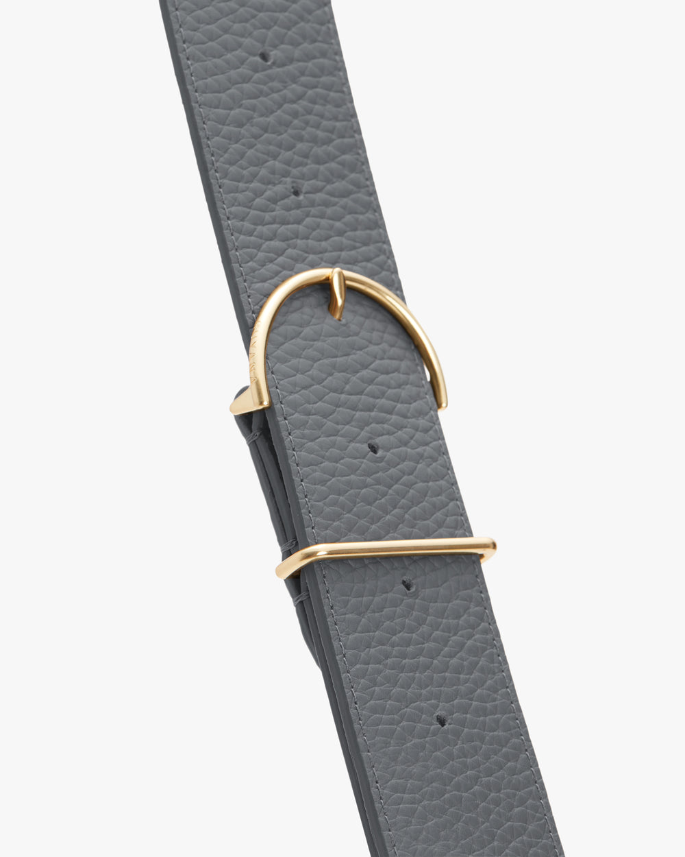 Belt with textured surface and a shiny metal buckle.