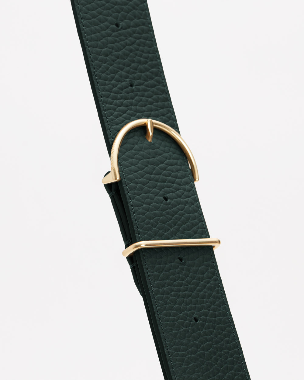 Close-up of a textured belt with a metal buckle.
