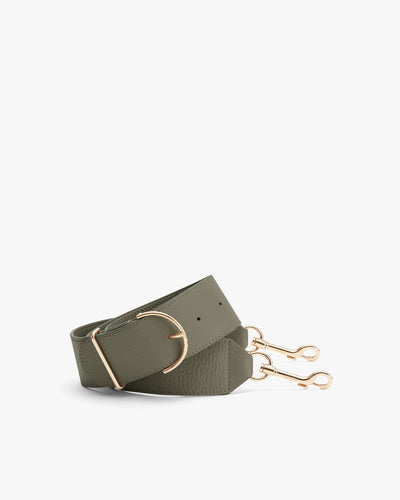 Bag strap with metal buckle and clips on a plain background.