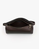 Open leather travel bag with visible interior and zippered opening.
