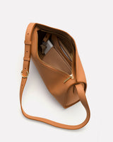 Open handbag with visible items inside and an adjustable strap.