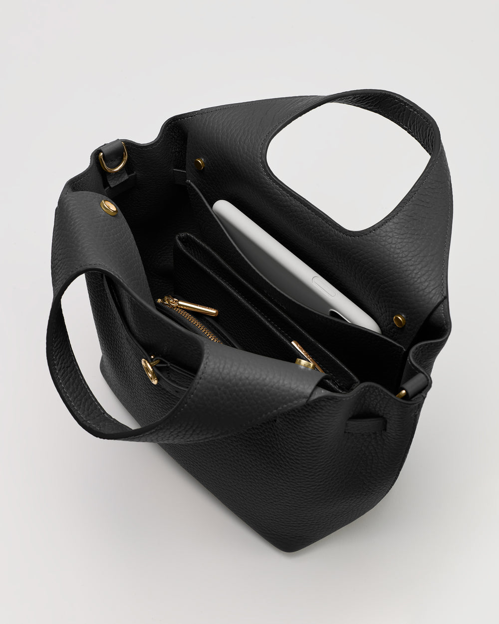 Open purse with contents visible including a tablet and pockets.