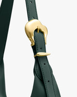 Close-up of a stylish bag strap with a shiny buckle.