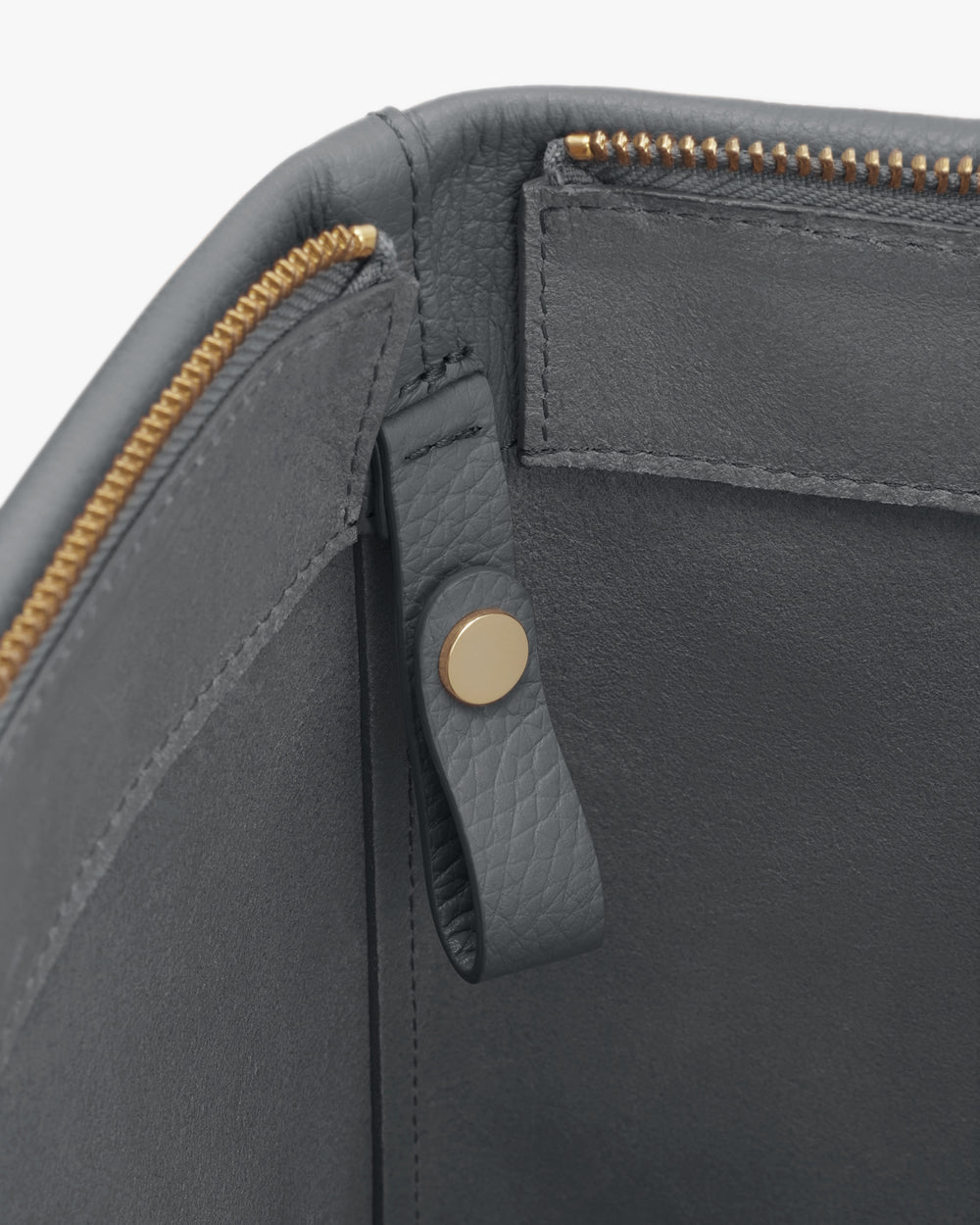 Open bag interior with a zipper and snap button detail