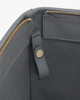 Open bag interior with a zipper and snap button detail