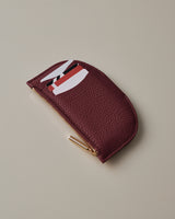 Half-circle zippered coin pouch with cards partially visible.