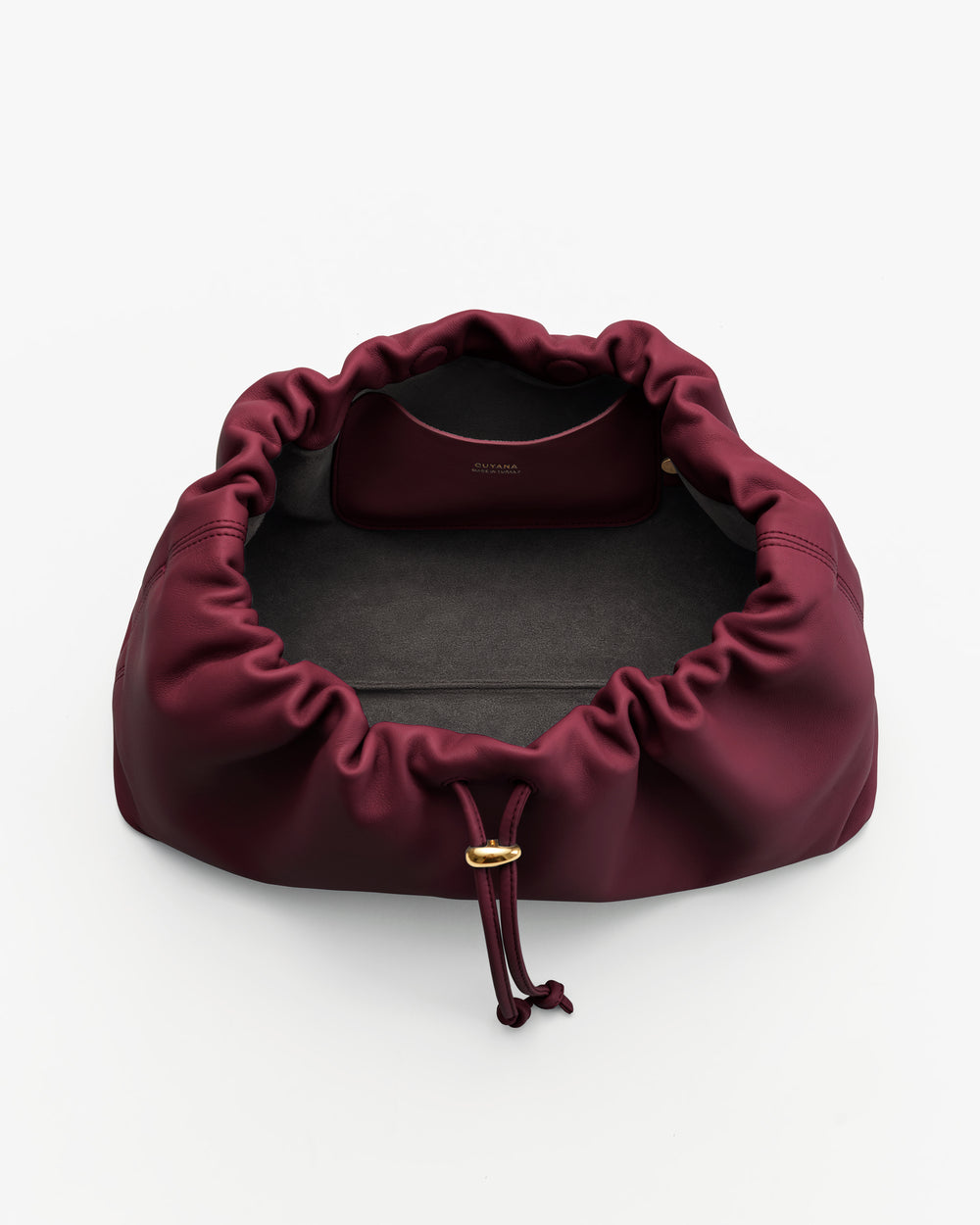Open drawstring bag with visible interior pocket and gold clasp.