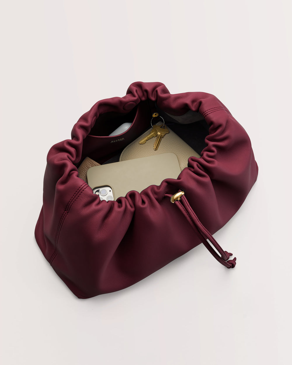 Open handbag with phone, keys, and wallet inside