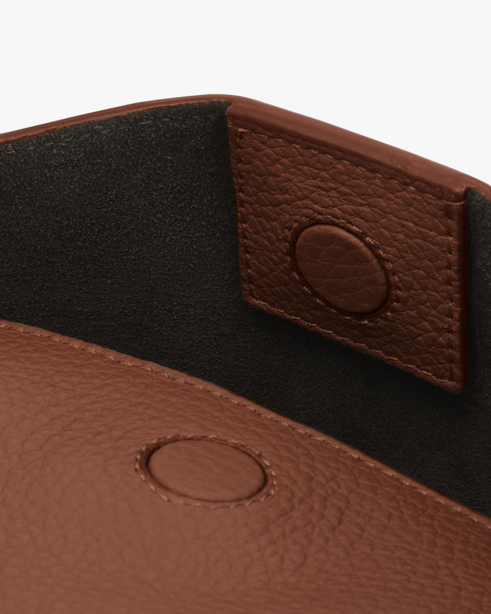 Close-up of open leather card holder with magnetic button closures.