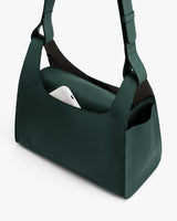 Handbag with a phone in the external pocket.