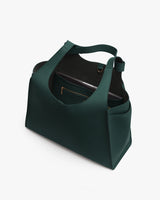 Open handbag with interior pocket and electronic device inside.