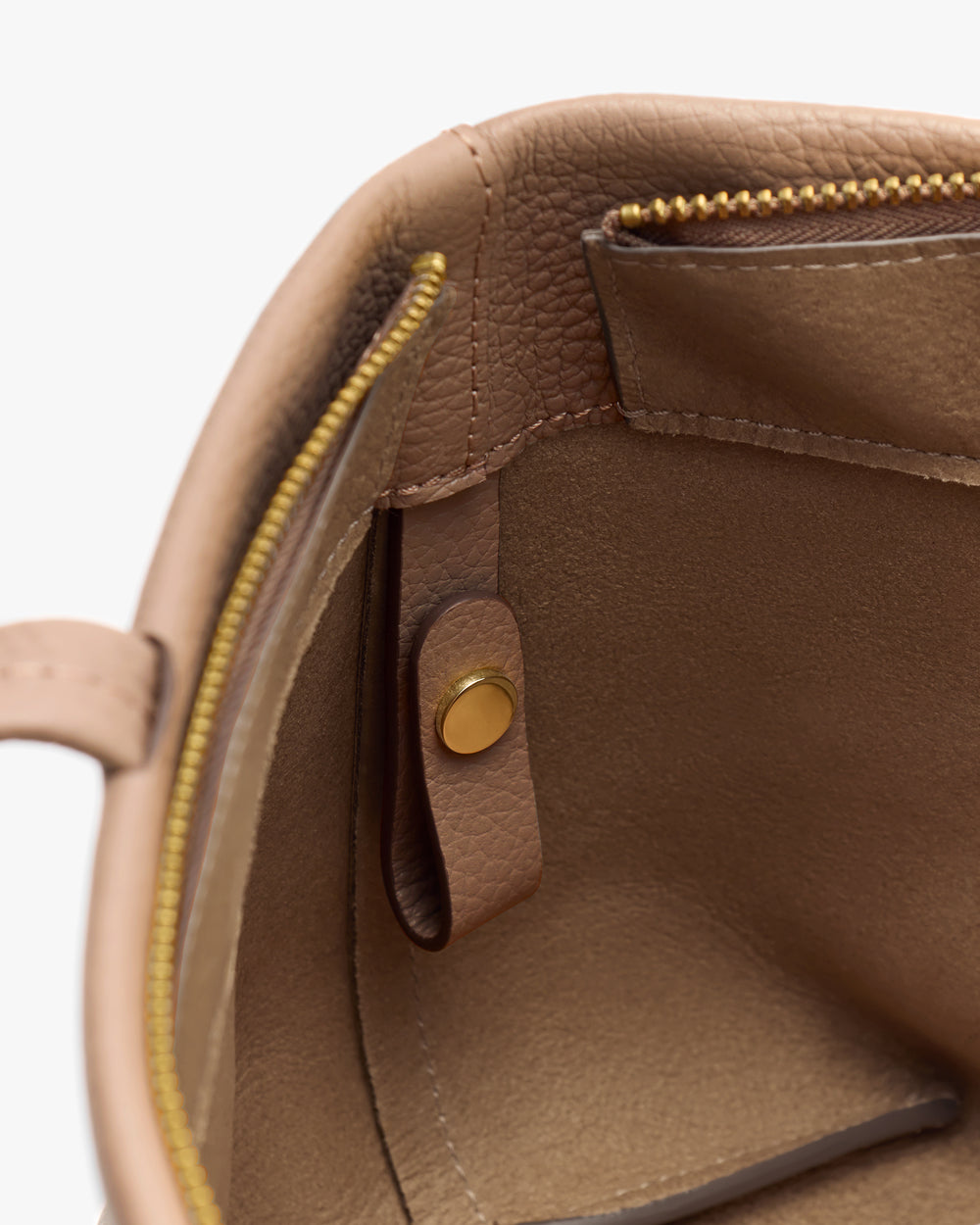 Close-up of an open handbag showing interior pockets and stitching.