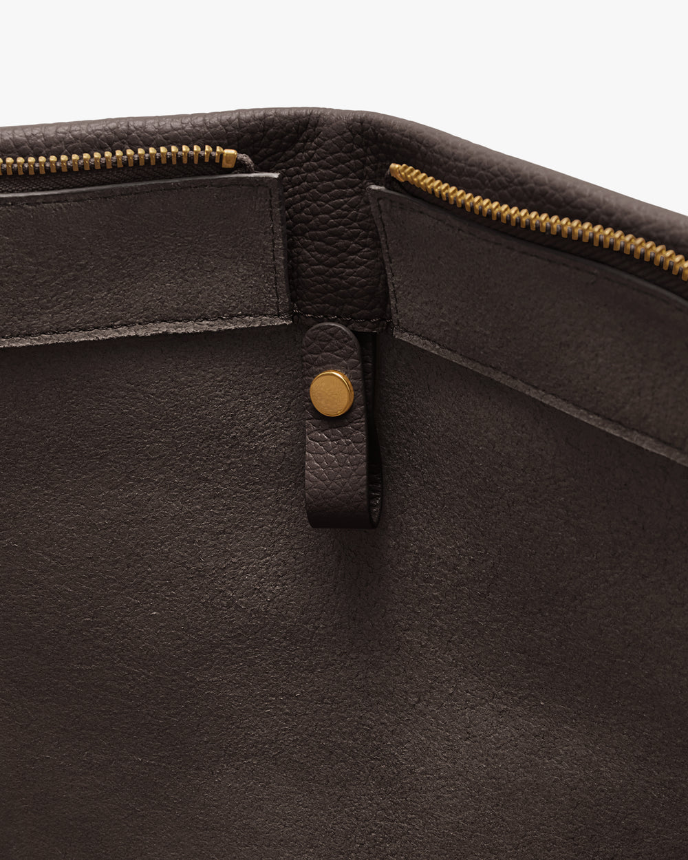 Close-up of an open bag with zipper and button detail.