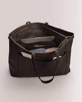 Large open tote bag with clothes and papers inside
