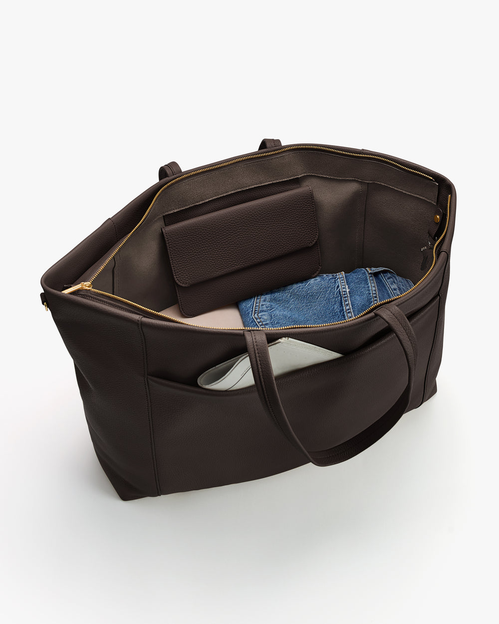 Open travel bag showing clothing and a purse inside