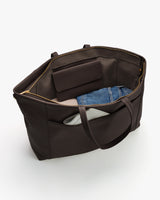 Open travel bag showing clothing and a purse inside