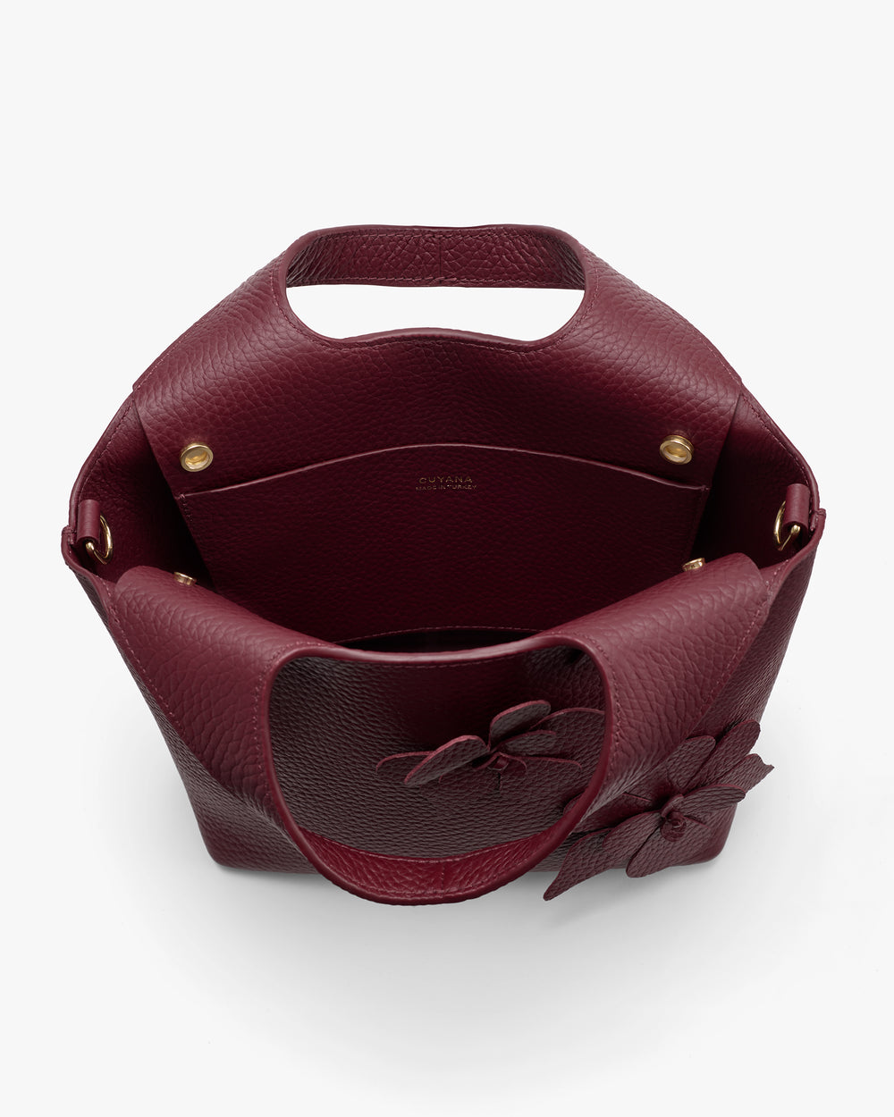 Open handbag with flower detail and handle.