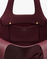 Open handbag showing interior pocket with brand logo.