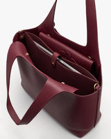 Open tote bag with a folder and notebook inside.