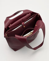 Open tote bag with multiple compartments and items inside.