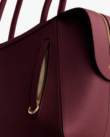 Close-up of a textured handbag with a zipper pocket and strap.