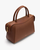 Handbag with curved top handles and a zippered closure