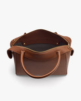 Top view of an open handbag with zipper and handles.