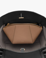 Open handbag with an inner zip compartment and a pouch inside.